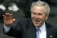 Then US President George Bush waves at onlookers as he arriv