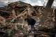 A woman amid wreckage from Russian bombardment in Ukraine, s