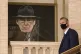 Edwin Poots walks past a portrait of former party leader Ian