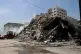 Workers clear the rubble of a building in Gaza that was dest