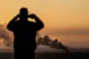 BARBARITY: A man looks at smoke rising following an explosio