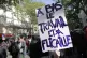 Demonstrators hold a placard reading: ‘Down with work and 