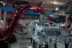 Visitors watch robotic arms assemble a car during the World 