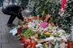 TRAGEDY: A man lays flowers
at a memorial marking the spot
w