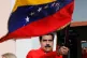President Nicolas Maduro waves a Venezuelan flag