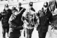Police lead away an injured picketer at Orgreave Coking Plan