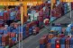 Trucks move amid containers stacked at a container terminal port on the Yangtze River in southwest China's Chongqing Municipality on April 20, 2025