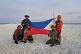 n this photo provided by the National Task Force West Philippine Sea (NTF-WPS), Philippine inter-agency members which included Philippine Navy, Philippine Coast Guard and Philippine National Police - Maritime Group, hold the Philippine flag as they visit Sandy Cay 2 at the South China Sea, April 27, 2025