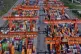 Trucks move past piles of containers stacked at a container terminal port on the Yangtze River in southwest China's Chongqing Municipality on April 20, 2025