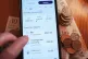 A person using a banking app on their phone showing the amount of spending on bills, April 1, 2025