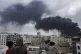 Yemenis watch as smoke billows following Israeli airstrikes targeting a power plant and Sanaa Airport, in Sanaa, Yemen, May 6, 2025