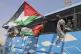 Members of a humanitarian convoy of at least 1,500 people, including activists and supporters from Algeria and Tunisia, wave Palestinian flags from a bus as the group travels toward Gaza via Egypt's Rafah Crossing, in Zawiya, Libya, June 10, 2025