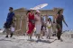 Tourists with an umbrella walk in front of the ancient Parthenon temple at the Acropolis Hill, June 26, 2025, as the summer's first heat wave hits Greece
