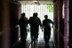 A Prison Officer accompanies inmates along a corridor at HMP Feltham B, Middlesex, Young Offenders Institut