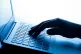 A woman's hand pressing keys of a laptop keyboard
