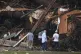 People look at debris on the banks of the Guadalupe River after a flash flood swept through the area, July 5, 2025, in Hunt, Texas