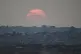 The sun sets behind buildings that were destroyed by the Israeli military in the northern Gaza Strip, August 8, 2025