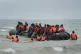 People thought to be migrants scramble to board a small boat near Wimereux in France, July 17, 2025