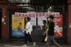 Residents walk past a residential entrance gate displaying a slogan urging mosquito control, in Guangzhou, south China's Guangdong Province, August 6, 2025