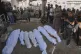 Palestinians pray over the bodies of people who were killed in an Israeli military strike, during their funeral outside Shifa Hospital, in Gaza City, August 22, 2025