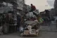 Displaced Palestinians fleeing Jabaliya move with their belongings on a street in Gaza City, August 26, 2025