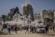 Palestinians run for cover during an Israeli airstrike on a high-rise building in Gaza City, September 5, 2025