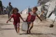 Displaced Palestinians girls carry a jerrycan after collecting water from a distribution point at a tent camp in Muwasi, an area that Israel has designated as a safe zone, in Khan Younis southern Gaza Strip, Monday, Sept. 29, 2025