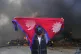A protester shouts slogans carrying national flag after burning down a police station during protests against social media ban and corruption in Kathmandu, Nepal, September 9, 2025