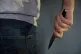 A model posing while holding a knife