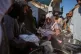 Palestinians receive donated food at a community kitchen in Deir al-Balah, central Gaza Strip, October 16, 2025