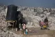 Palestinians collect water amid the ruins of Gaza City, October 26, 2025