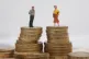 Plastic models of a man and woman stand on a pile of coins