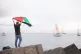 A man waves a Palestinian flag as the Thousand Madleens ship sets sail for Gaza [Pic: Antonio Vasquez]