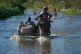 People traverse a road flooded by Hurricane Melissa on the southern coast of Santiago de Cuba, Thursday, Oct. 30, 2025