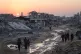 Palestinians walk among destroyed buildings in Khan Younis, southern Gaza Strip, November 2, 2025