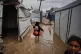 DETERIORATING CONDITIONS: Palestinians walk through a flooded temporary tent camp after heavy rainfall in Deir al-Balah, central Gaza Strip; 