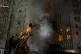 In this photo provided by the Ukrainian Emergency Services on December 8, 2025, a rescue worker puts out a fire of a residential building damaged by a Russian strike in Sumy region, Ukraine