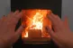 A person warms their hands on a wood-burning stove at a home in Whimple, East Devon, January 10, 2025