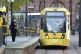 Commuters wait to board a tram in Manchester