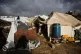 Nouzha Owkal, cleans her tent after it was damaged by a storm at a displacement camp in Zawaida, central Gaza Strip, January 13, 2026