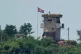 A soldier stands at a North Korean military guard post with the country's national flag, seen from Paju, South Korea, June 26, 2024