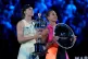 Elena Rybakina, left, of Kazakhstan holds the Daphne Akhurst Memorial Cup after defeating Aryna Sabalenka, right, of Belarus to win the women's singles final at the Australian Open tennis championship in Melbourne, Australia, January 31, 2026
