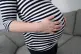 A pregnant woman holding her stomach, December 31, 2017