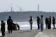 People observe a moment of silence at 2:46 p.m., the moment the earthquake struck with a backdrop of Fukushima Daiichi nuclear power plant in Namie, Fukushima prefecture, northern Japan. Photo: Kyodo News via AP