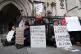 Protesters hold placards outside the High Court, central London, February 13, 2026