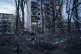 A woman with a dog walks among the rubble of a house damaged after a Russian strike on residential area in Kyiv, Ukraine, April 16, 2026