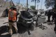 Palestinian civil defense crews work on a destroyed car after it was struck in an Israeli strike in Gaza City, April 28, 2026