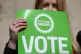 Scottish Green party supporters hold placards 