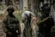 Palestinians collect belongings from their destroyed homes in the Tulkarem refugee camp in the occupied West Bank as Israeli soldiers stand nearby, June 17, 2026