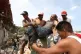 Neighbours carry a man rescued from the rubble of a collapsed building the day after earthquakes struck La Guaira, Venezuela, June 25, 2026